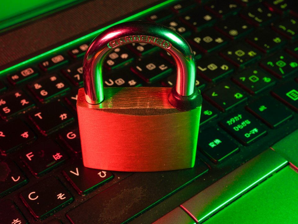 A red padlock resting on a backlit keyboard